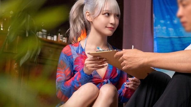施術前の美菜ちゃんがクリップボードを受け取り、男性の前で落ち着いた表情を見せる